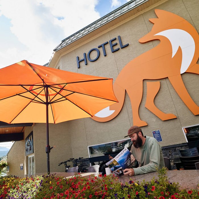 man sitting in front of Fernie Fox Hotel sign